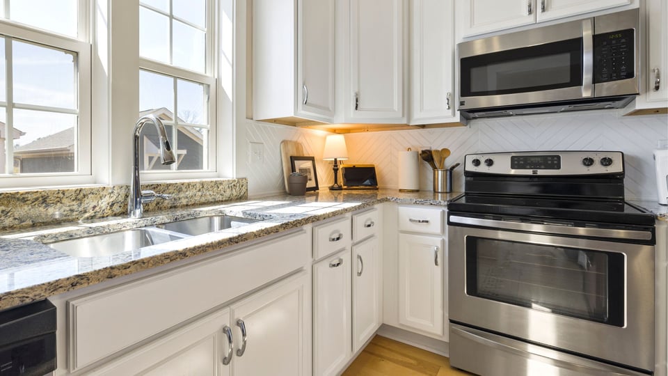 Arizona kitchen with granite countertops, stainless steel appliances, and white cabinets