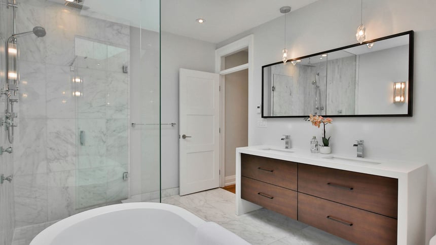 bathroom remoedl with glass walk in shower and floating double sink vanity