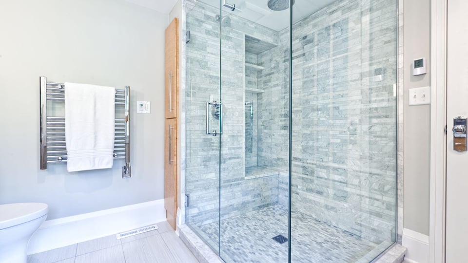 statement tile shower with blue green tile and glass shower door