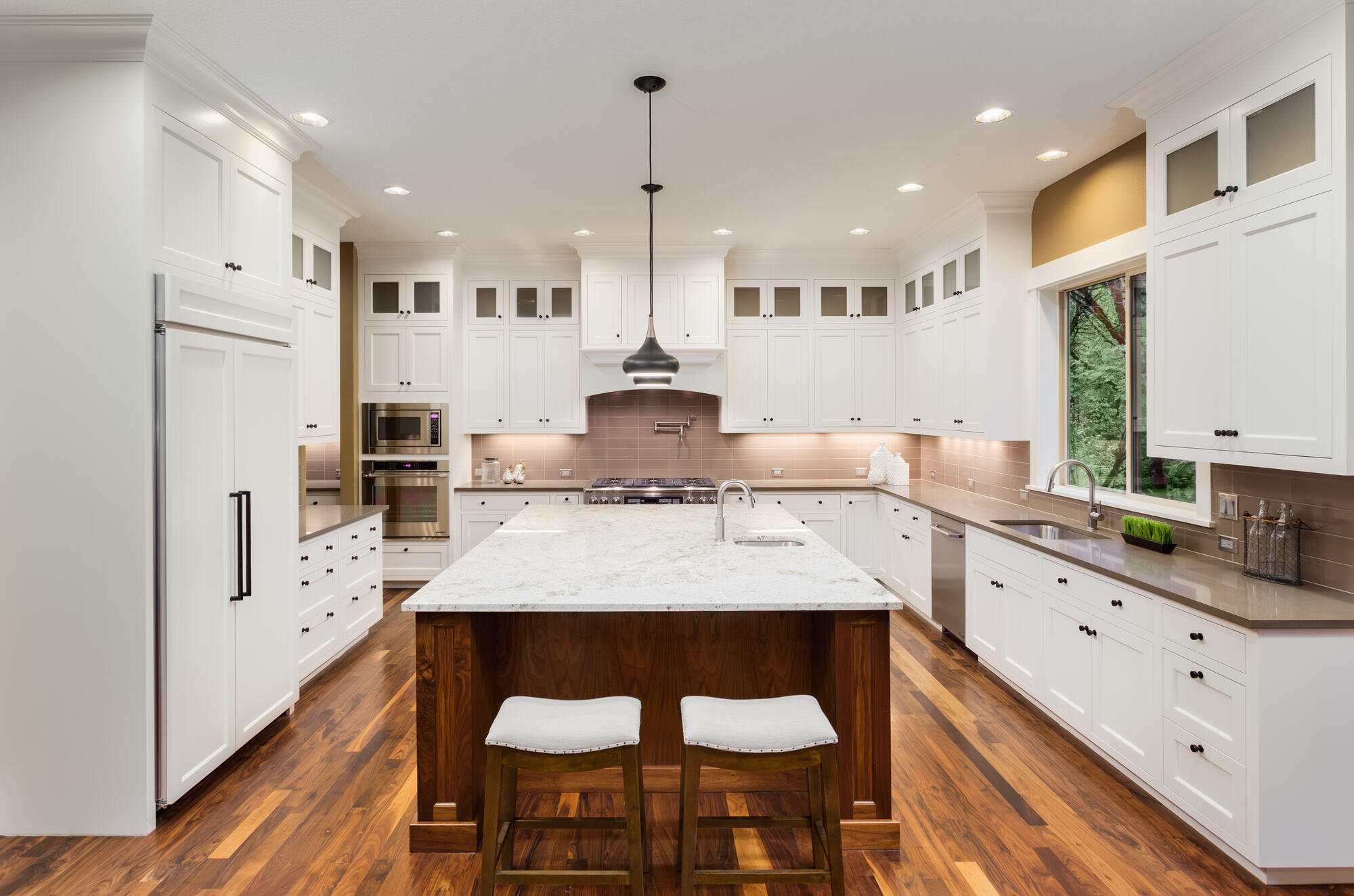 Stylish open-concept kitchen remodel by Crosby Home Services in Prescott, AZ, with natural wood flooring and a marble island