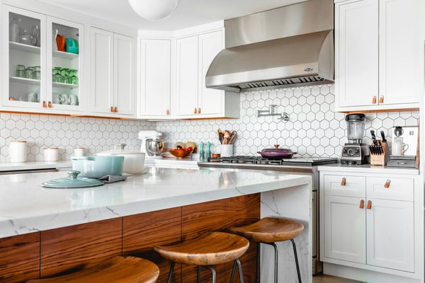 Chic kitchen remodel with white cabinetry, hexagon backsplash tiles, and wood accents in Prescott, AZ by Crosby Home Services