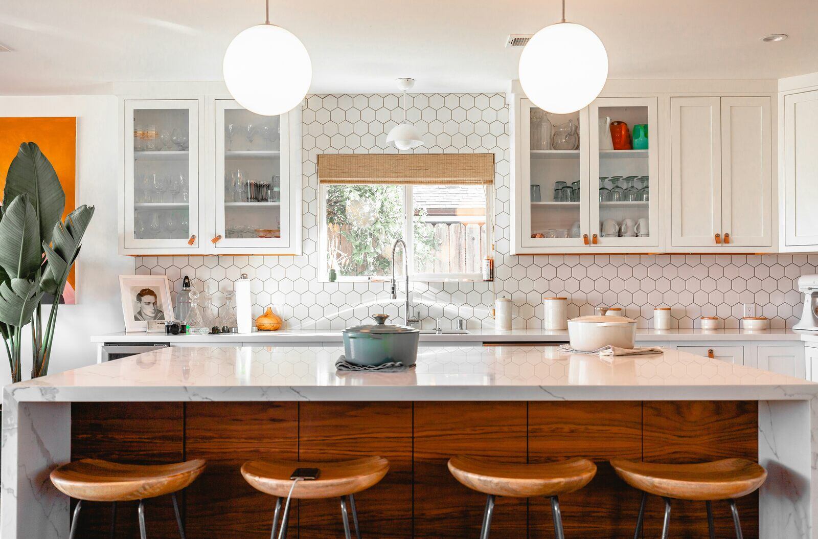 Modern kitchen remodel with a spacious white island, wood stools, and open shelving in Prescott, AZ by Crosby Home Services