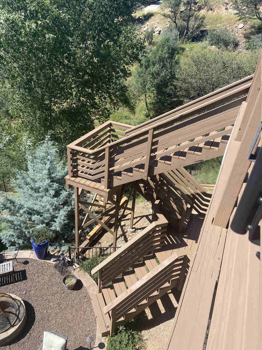 A multi-level wooden staircase leading to a patio with scenic forest views, built by Crosby Home Services in Prescott, AZ