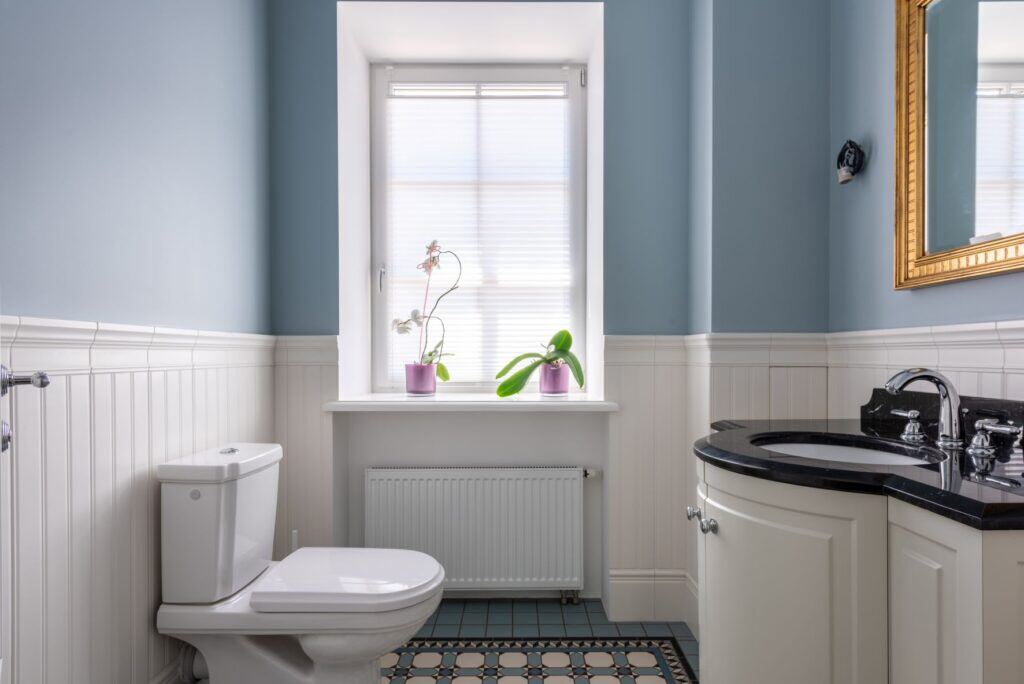 bathroom remodel with blue walls and black and white sink vanity