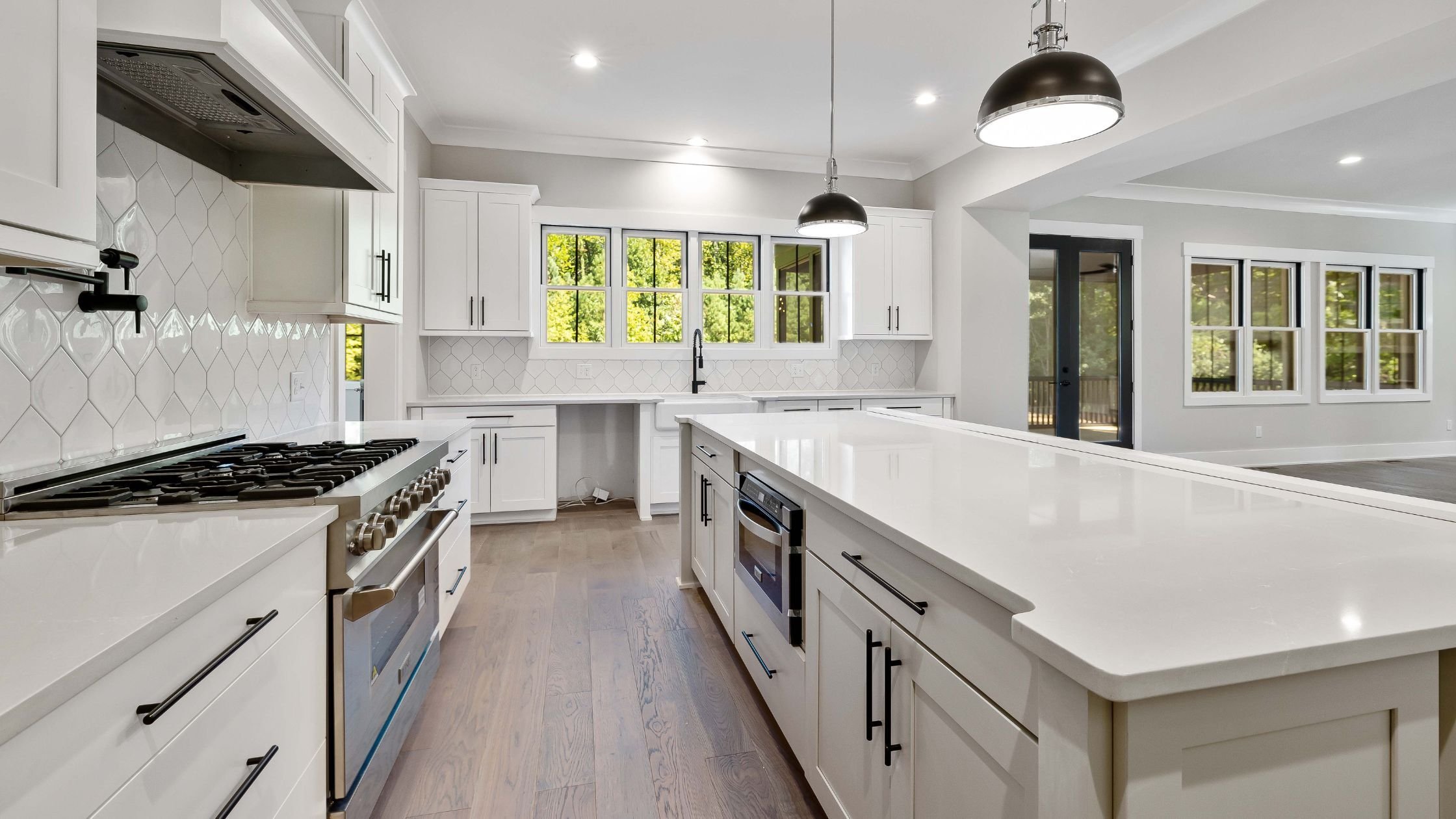 kitchen remodel with white shaker cabinets and black hardware with large island