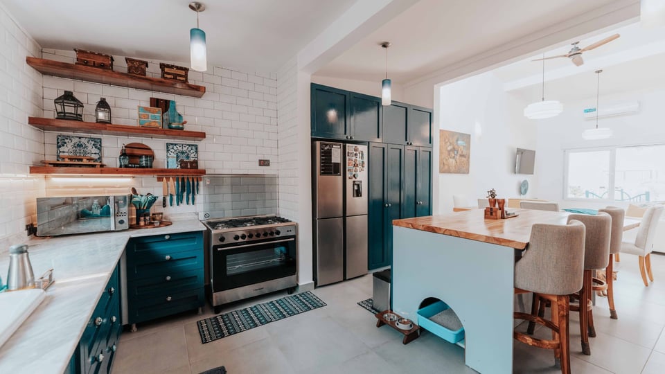 open concept kitchen with open shelves and white subway tile with teal shaker cabinets
