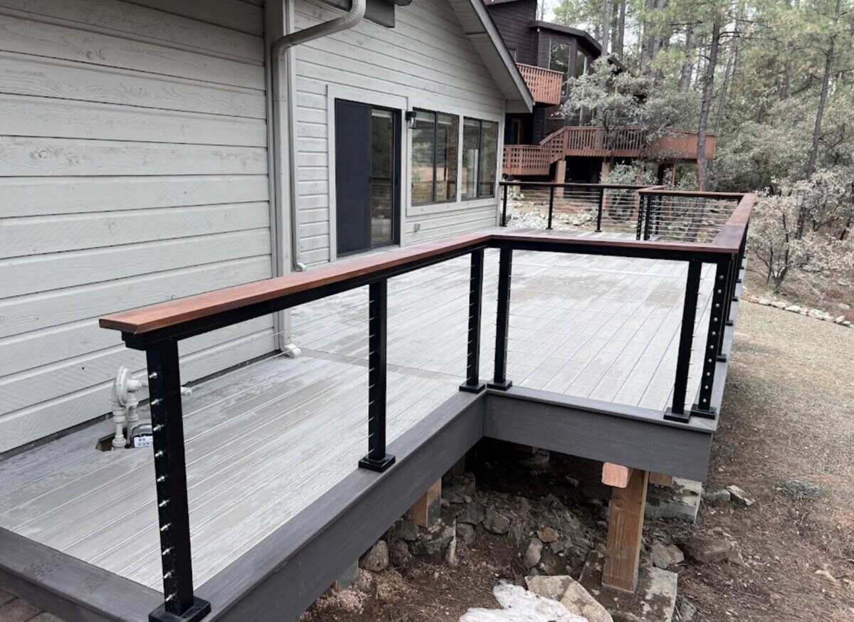 Modern gray deck featuring black railing with wooden accents, part of a home upgrade project by Crosby Home Services in Prescott, AZ