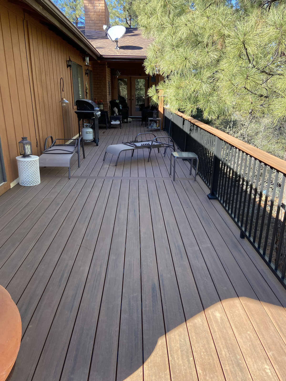 Rustic outdoor deck surrounded by trees, completed by Crosby Home Services in Prescott, AZ